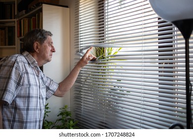 COVID-19 Quarantine Mental Health. Elderly Man Looking Out On Window, Isolation, Loneliness, Social Distancing