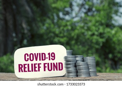 Covid-19 Relief Fund Tag With Stack Of Coin On Wooden Surface In Horizontal Orientation