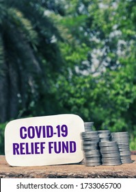 Covid-19 Relief Fund Tag With Stack Of Coin On Wooden Surface In Vertical Orientation