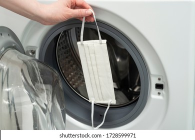 COVID-19 Reusable Cloth Face Mask In The Washing Machine After Wearing At Work, Public Place, Transport. Woman Washes Homemade Cotton Mouth Masks.