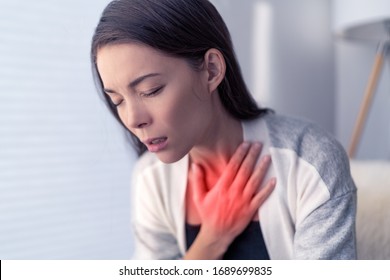 COVID-19 shortness of breath Coronavirus cough breathing problem. Asian woman touching chest in pain with red highlighted area. respiratory symptoms fever, coughing, body aches. - Shutterstock ID 1689699835