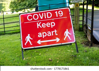 A Covid-19 Social Distancing Warning Sign At An Outdoor Event.