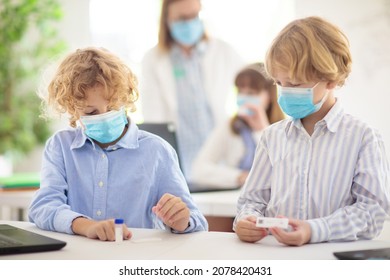 Covid-19 Test In School. Rapid Coronavirus Antigen Testing For Students In Classroom. Kid Doing Swab Test Kit In Class. Teacher In Face Mask Checking Health Exam Results. Safe Education In Pandemic.