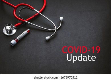COVID-19 UPDATE text with stethoscope and blood sample vacuum tube on black background. Covid or Coronavirus Concept 
