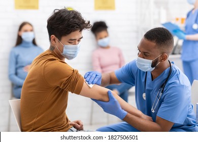 Covid-19 Vaccination. Asian Man Receiving Coronavirus Vaccine Intramuscular Injection In Arm During Doctor's Appointment In Hospital. Corona Virus Immunization, Protection, Medicine Treatment Concept - Shutterstock ID 1827506501