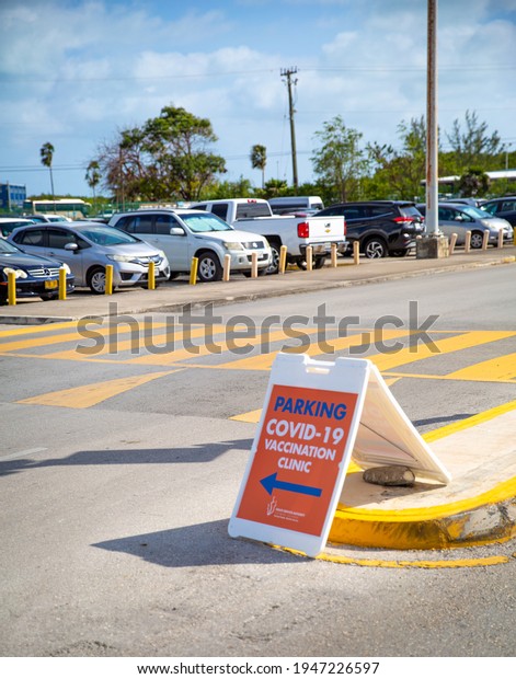 COVID-19
Vaccination Clinic Sign.  people walking, to get vaccinated.  Cars,
traffic.  Owen Roberts Airport, terminal.  Grand Cayman, Cayman
Islands.  Caribbean.  March 9rd 2021
