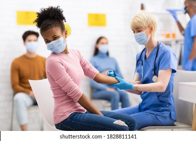 Covid-19 Vaccination. Doctor Vaccinating Black Teen Girl Against Coronavirus, Injecting Corona Virus Vaccine Injection In Arm Sitting In Hospital. Covid 19 Protection And Immunization - Shutterstock ID 1828811141