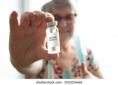 Covid-19 Vaccine Bottle In The Hand Of Senior Woman, Who Are Smiling Happy To Get Vaccination On The Background