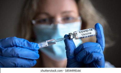 COVID-19-Impfstoff in den Händen der Forscher, weibliche Ärztin hält Spritze und Flasche mit Impfstoff gegen Koronavirus-Heilung. Konzept für die Behandlung, Injektion, Aufnahme und klinische Studie während der Pandemie.