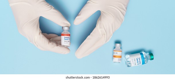 COVID-19 Vaccines For Developing Country Concept. Hand Of A Researcher Holding Coronavirus 2019-nCoV Vaccine Vials. Together, Financial Support Poor Nations, Alliance, Unicef, WHO, G20, Promised.