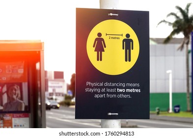 Covid-19 Warning Sign On A Pole Urging People To Keep Physical Distancing 2 Metres Apart From Others     