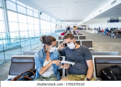 COVID-19 worldwide borders closures. Couple with face mask stuck in airport terminal after being denied entry to other countries. Passengers stranded in airport on his travel back to home country.