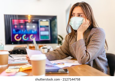 Covid-19. Young People With Face Masks Back At Work In Office After Lockdown.Asian Small Business Startup Multiracial Brainstorm Meeting With Laptop  And Everyone Mask For Covid19 Protection Corona.