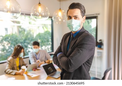 Covid-19. Young People With Face Masks Back At Work In Office After Lockdown.Asian Small Business Startup  Brainstorm Meeting With Laptop And Chart Paper Everyone Mask For Covid19 Protection Corona.