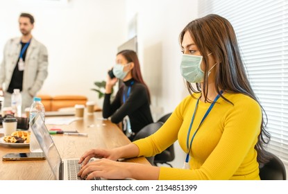 Covid-19. Young People With Face Masks Back At Work In Office After Lockdown.Asian Small Business Startup Multiracial Brainstorm Meeting With Laptop And Everyone Mask For Covid19 Protection Corona.