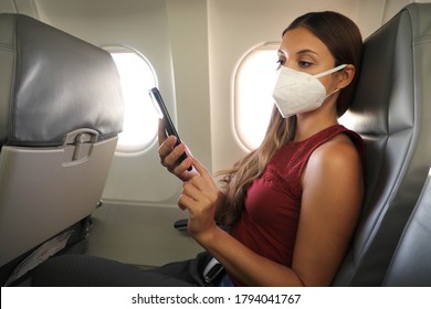 COVID-19 Young Woman Wearing KN95 FFP2 Mask Reading Ebook On Mobile Phone By Plane