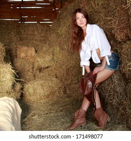 Cow Girl With Long Dark Hair In A Hat In The Hayloft