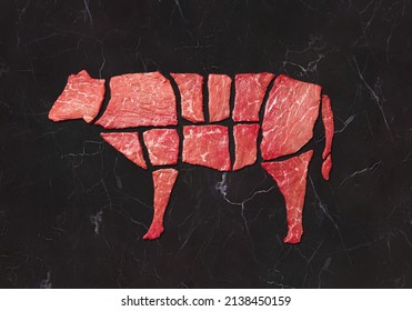 Vaca compuesta de trozos de carne de buey de mármol negro. Concepto creativo carne de ternera con mermelada. Vista superior, espacio de copia