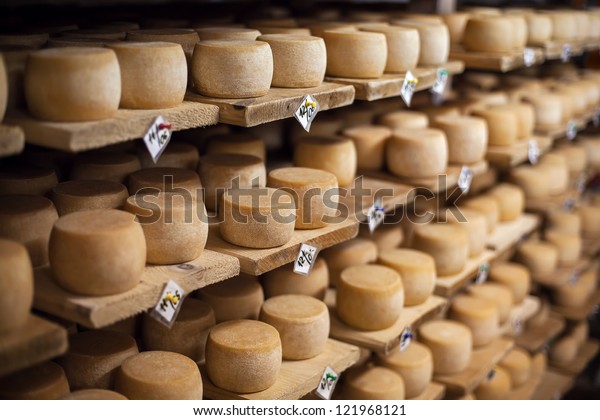 Cow milk cheese, stored in a wooden shelves and\
left to mature