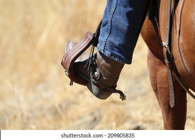 A Cowboy Boot In Saddle Stirrup.