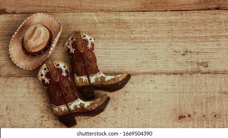 cowboy boots and hat on a wood background with vintage effect and writing space