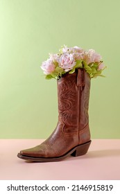 Cowboy boots shoes and bouquet of rose flowers on green background minimal creative concept symbol of wild west america usa texas and party.