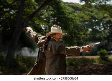 Cowboy Carrying A Gun In The Forest