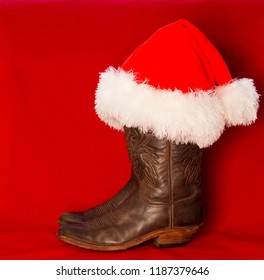 Cowboy Christmas background with traditional American cowboy boots and red Santa hat
