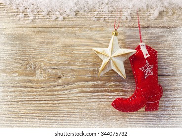 Cowboy christmas background with western toy boot and star on wood texture