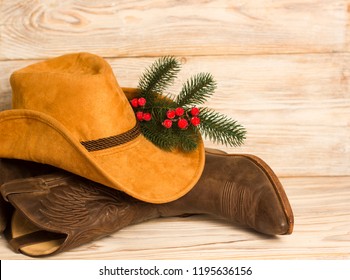 Cowboy Christmas.American West traditional boots and hat on wood background texture