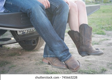 Cowboy And Cowgirl Hanging Off A Tailgate