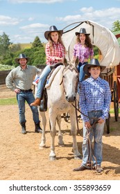 Cowboy Family Of Four With Wagon And Horse