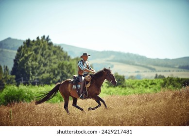 Cowboy, fast and man riding horse with saddle on field in countryside for equestrian or training. Nature, summer and speed with mature horseback rider on blue sky at ranch outdoor in rural Texas - Powered by Shutterstock