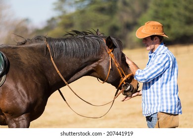 cowboy feeding his horse out of hand - Powered by Shutterstock