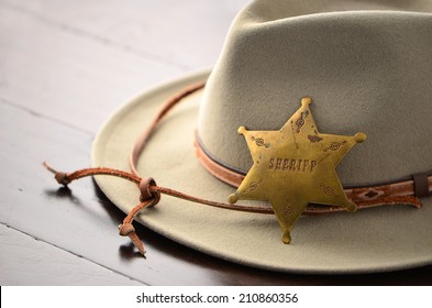 Cowboy Hat With Sheriff Badge On Wooden Background In Horizontal Format With Selective Focus