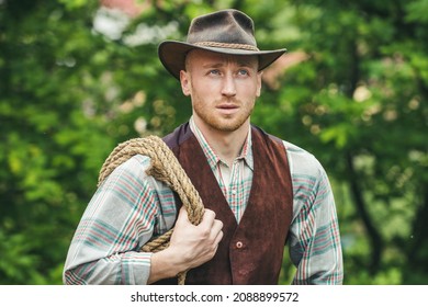 Cowboy With Lasso Rope On Green Background. Western Life. Handsome Bearded West Farmer. Portrait Of Man Cowboy Or Farmer. Western.