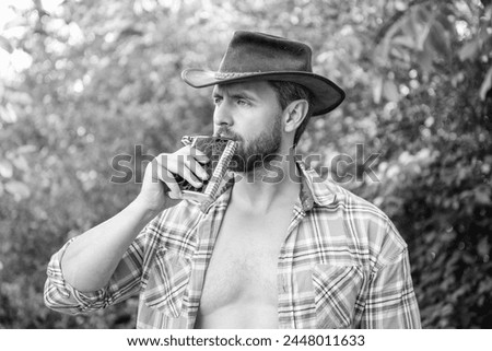 cowboy man drinking bourbon hipflask. man with bourbon hipflask outdoor.