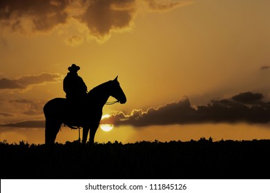 Cowboy, on horseback,silhouetted against the setting sun - Powered by Shutterstock