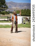 Cowboy, ranch and lasso in boots, sun and straps for wrangler and Texas farmer at stable. Mature man, wild west and summer in agriculture, hat and male person with rope in farm job and environment