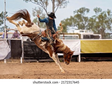 Cowboy riding a bucking bronc at a country rodeo Australia