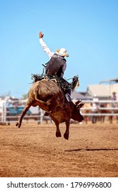 A cowboy riding a bucking bull at an Australian country rodeo