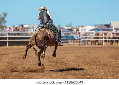 A cowboy riding a bucking bull in a rodeo competition