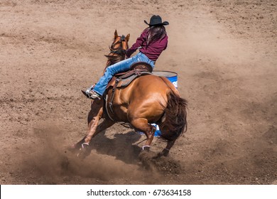 Cowgirl Riding Her Horse In A Barrel Racing Contest.