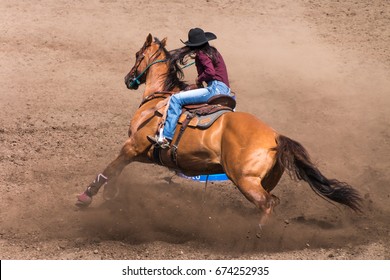 Cowgirl riding her horse in a barrel race at a rodeo