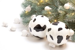 A Cow-like Christmas Ball On A Christmas Tree With A Garland. White Background. A Merry Holiday, Winter, The Year Of The Bull Concept. Copy Space. Horizontal. 