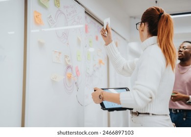 Coworkers collaborate in a corporate office, strategizing for business growth. They brainstorm, analyze data, and share ideas on sticky notes and a glass wall.