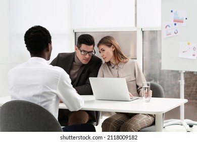 Coworkers Conducting Job Interview With African American Man In Office. Racism Concept