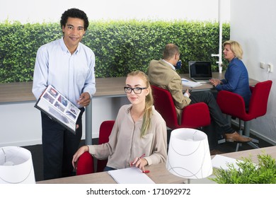 Coworkers Discussing A Project In An Open Office Space