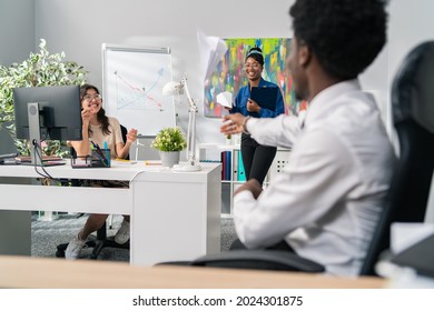 Co-workers Elegantly Dressed Sitting In The Office In The Corporation, Cheerful Work, Funny Atmosphere, Friends Throwing At Each Other Folded Paper Planes, Joking, Laughing, Business In The Company