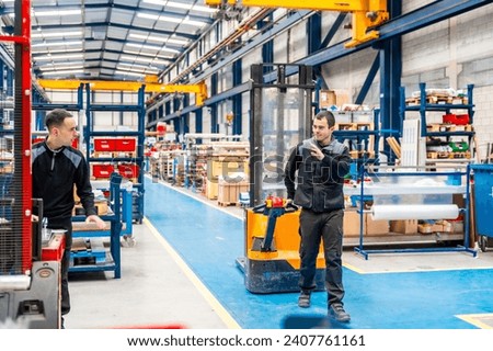 Coworkers taking while using handcart in a logistic center